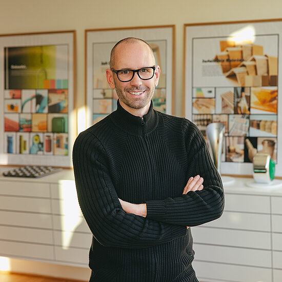 Vorwerk: Photo: The photo shows an upper body cut-out of Jan Delfs, Vorwerk Chief Designer, with his arms crossed in front of his stomach, smiling into the camera.
