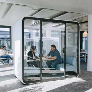 Vorwerk: Photo: Two people sit in a soundproof meeting box, also known as a think tank, and discuss a topic.