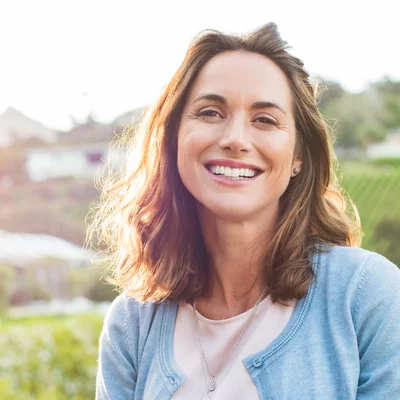 Vorwerk: Foto: Eine Frau steht in einem Weinberg, während die Sonne hell scheint.