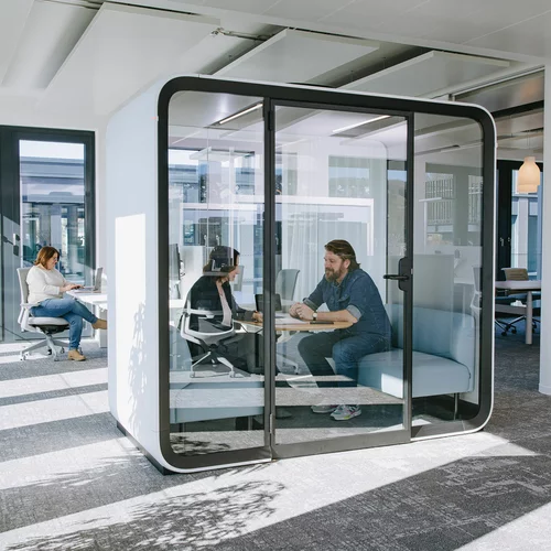 Vorwerk: Foto: Zwei Personen sitzen in einer schalldichten Meeting-Box, die man auch Think Tank, zu deutsch: Denkfabrik nennt, und tauschen sich zu einem Thema aus.