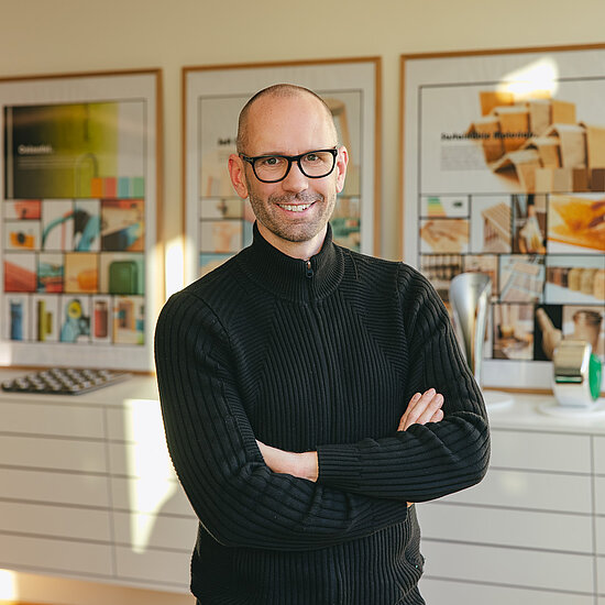 Vorwerk: Photo: The photo shows Jan Delfs, the chief designer at Vorwerk. He stands there with his arms casually crossed in front of his stomach and smiles directly into the camera.