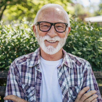 Vorwerk: Foto: Ein älterer Mann mit Brille und Bart sitzt auf einer Bank.